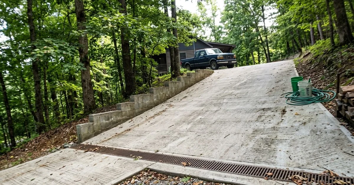 Steep sloped concrete driveway on a mountain lot with a drainage channel