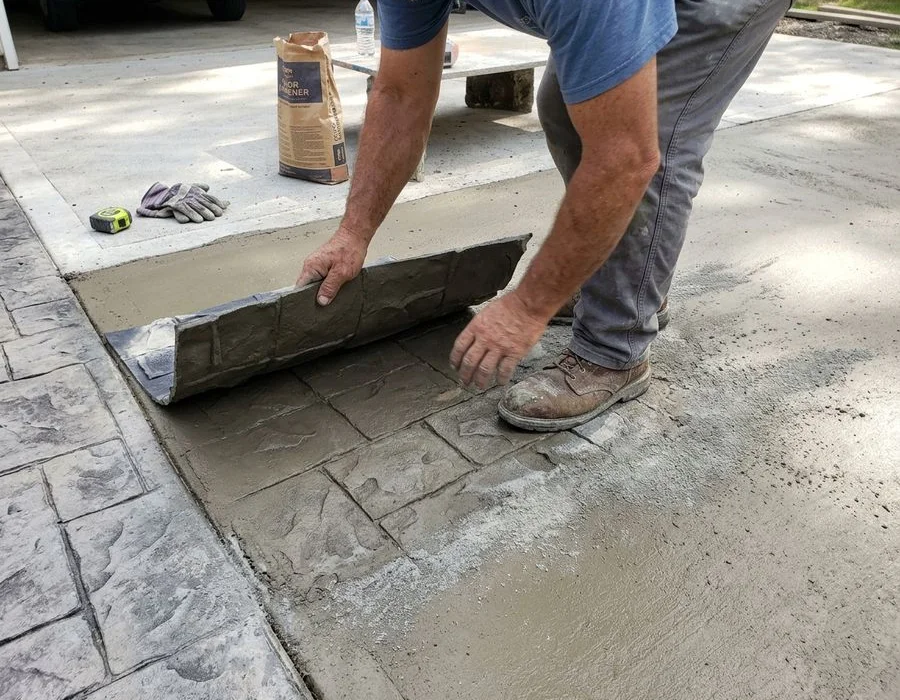 Pressing an Ashlar slate texturing mat into freshly poured colored concrete